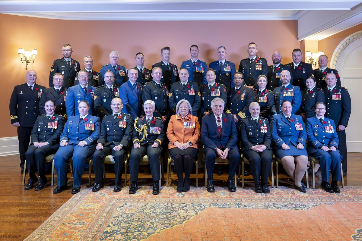 La gouverneure générale Simon et M. Fraser, assis au centre d'un grand groupe, posant pour une photo de groupe.