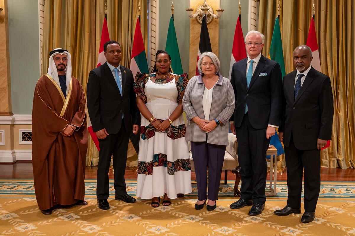 Une photo de groupe avec la gouverneure générale Simon et avec cinq nouveaux chefs de mission. Les drapeaux de chaque pays se trouvent derrière eux.