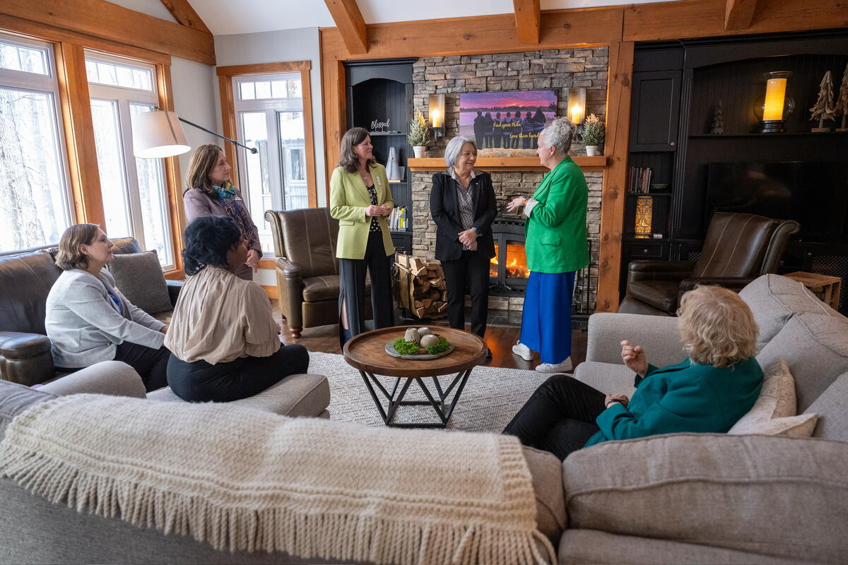 Un groupe de 7 femmes discutant à l'intérieur avec la gouverneure générale Mary Simon, certaines sont debout, d'autres sont assises sur un divan.
