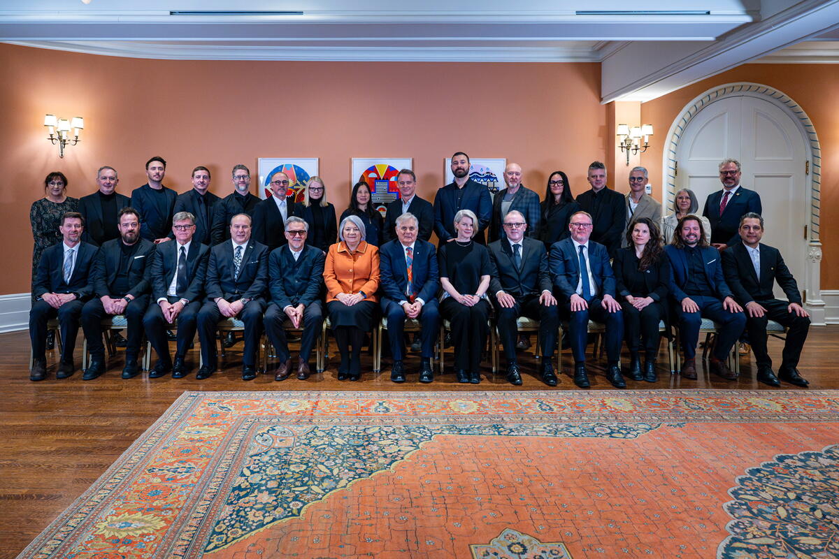 La gouverneure générale Simon et M. Fraser posant pour une photo de groupe avec les récipiendaires des prix. Il y a deux rangées de personnes. Une rangée est debout, l'autre est assise.