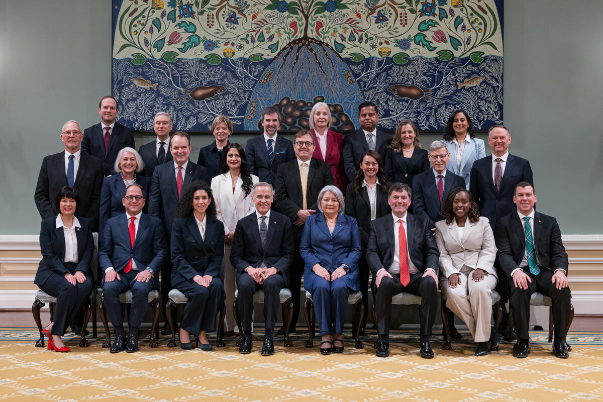 La gouverneure générale Simon et le Premier ministre Mark Carney sont assis au premier rang d'une photo de groupe dans la salle de bal de Rideau Hall. Ils sont entourés de membres du nouveau Conseil des ministres du Canada.