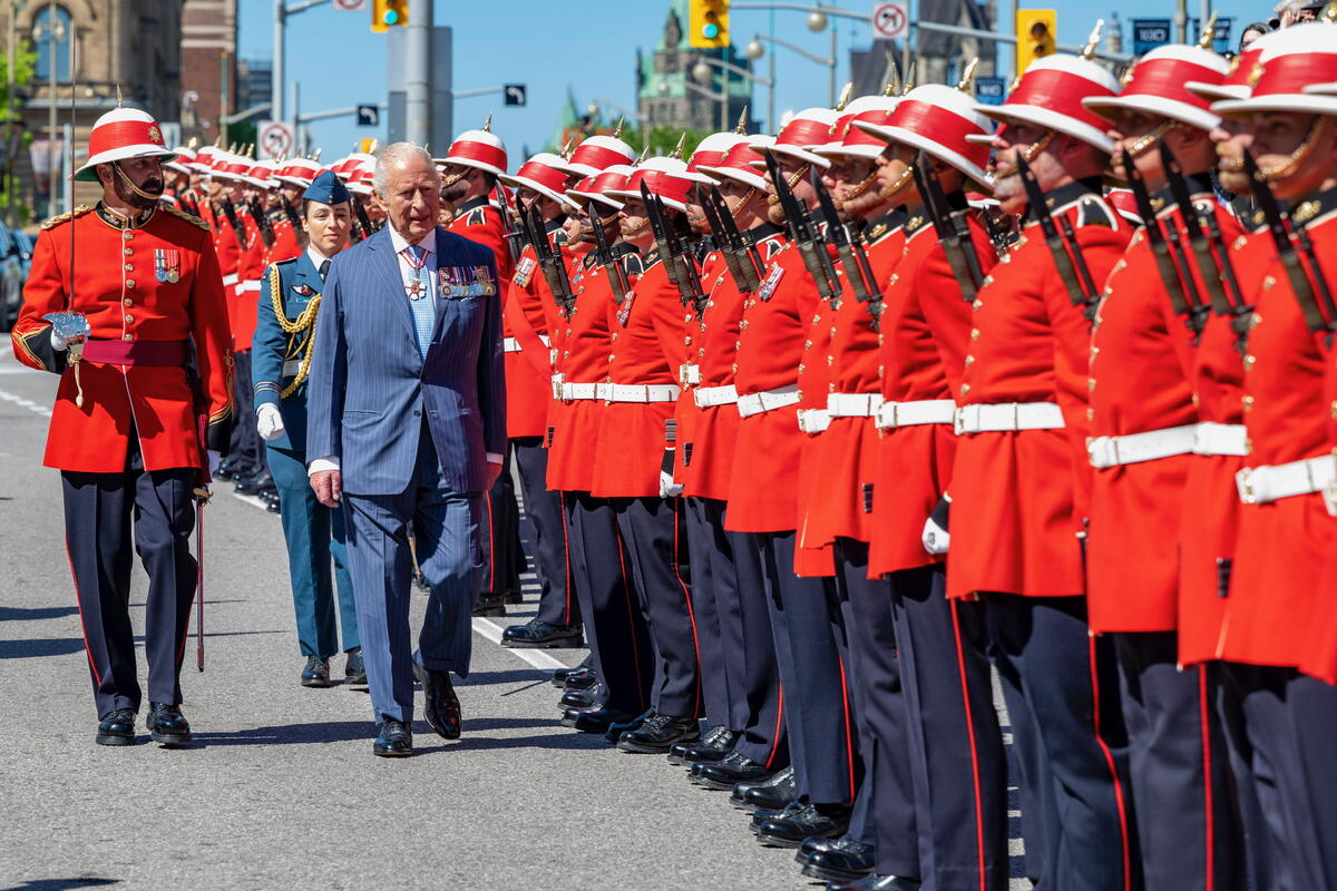 His Majesty inspecting an honour guard in formal military tradition.