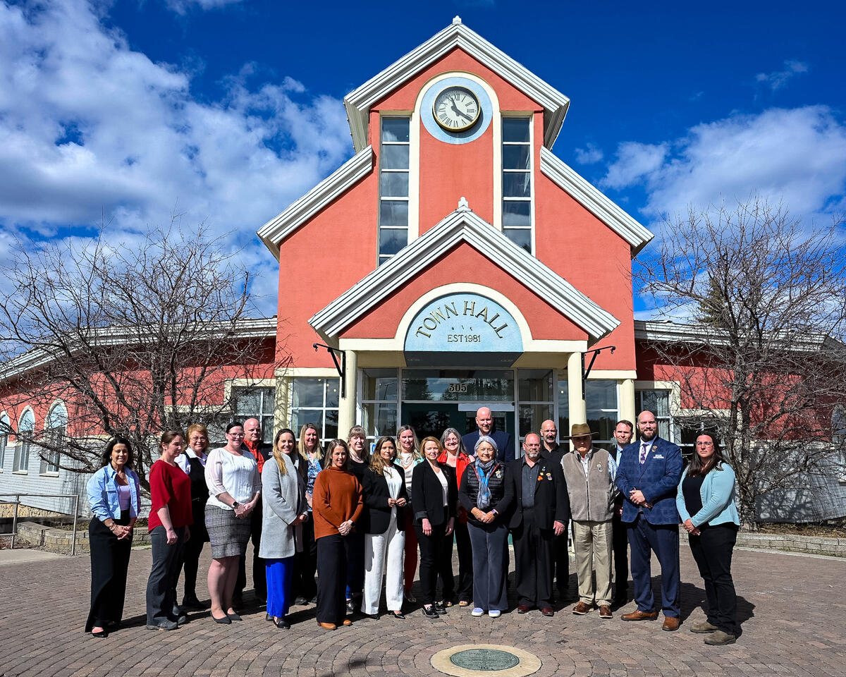 Governor General Mary Simon and Mr. Whit Fraser standing with a group of people in front of Town Hall in Tumbler Ridge.