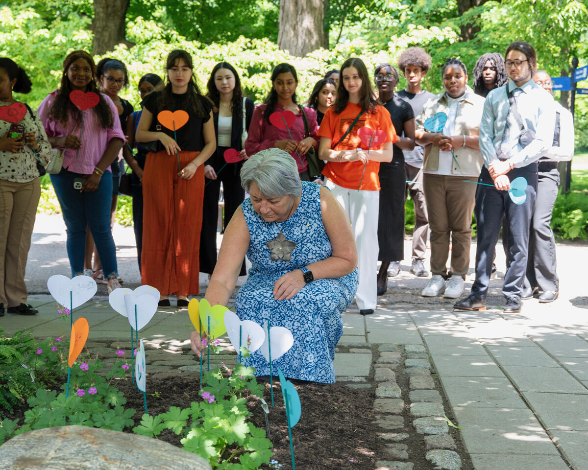 La gouverneure générale Mary Simon dépose un cœur en papier dans un jardin de cœurs, entourée de personnes tenant des cœurs en papier.