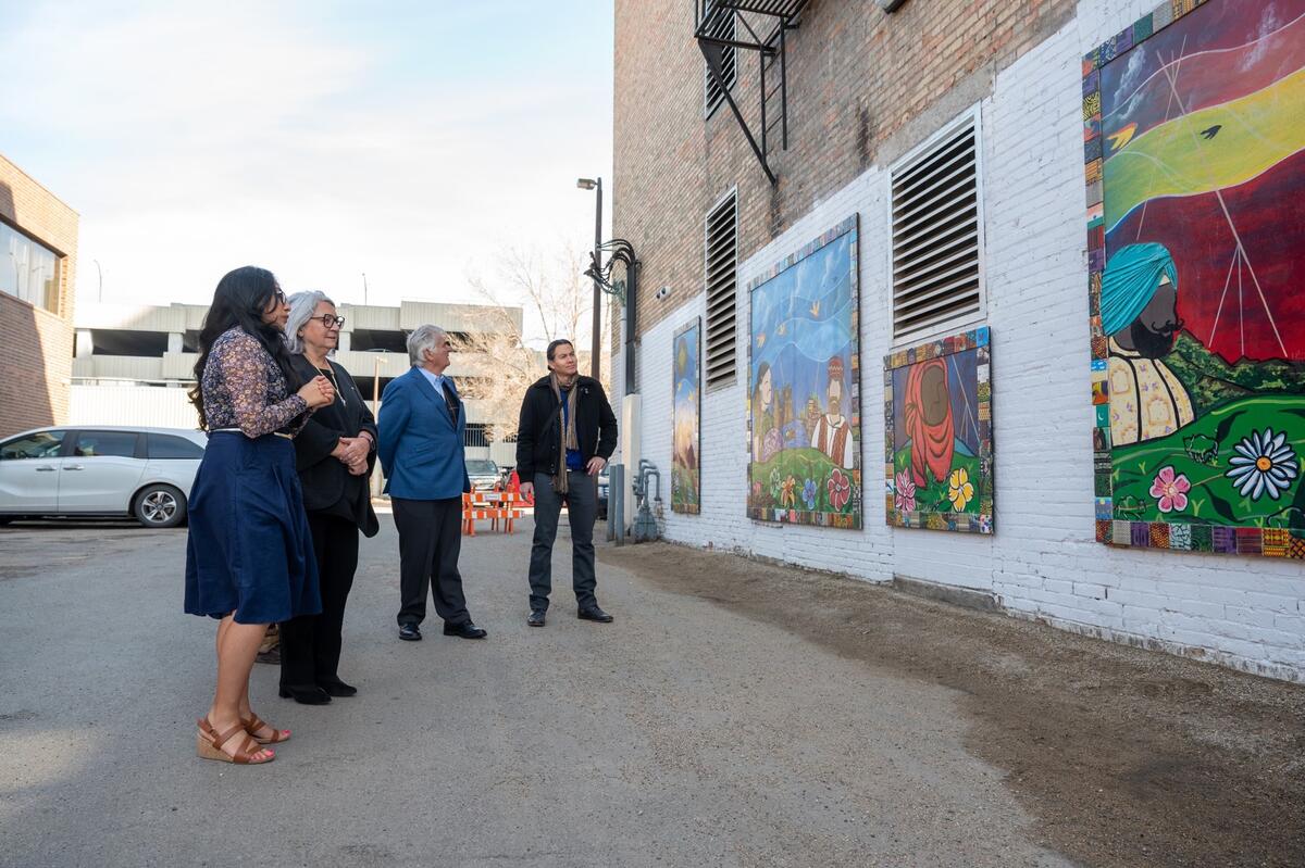 La gouverneure générale Simon, M. Whit Fraser et deux autres personnes devant une grande peinture murale.