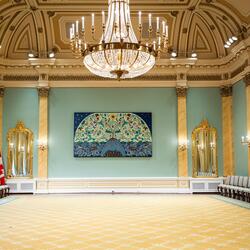 Salle de bal de Rideau Hall. Un lustre est suspendu au plafond. Une grande œuvre d'art est accrochée au mur du fond.