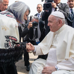 Governor General Simon is shaking hands with Pope Francis.