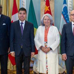 Governor General Mary Simon stands with the new heads of mission in front of their flags
