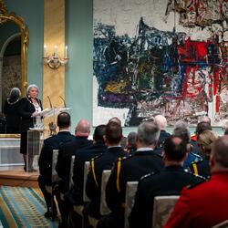 La gouverneure générale Mary Simon s'exprime sur un podium dans la salle de bal de Rideau Hall. Elle regarde une foule de récipiendaires de l'Ordre du mérite des corps policiers. Les récipiendaires portent des uniformes de police.