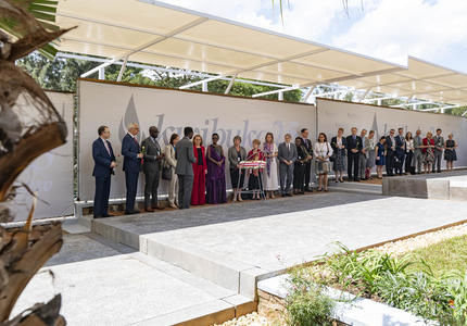 The Governor General and members of the Canadian delegation stand in a line at the Kigali Genocide Memorial. 