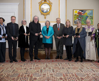 A group of people poses for the camera. Governor General Mary Simon and Mr. Whit Fraser are in the centre.