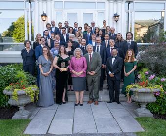 A group of people posing for a photo outside. Governor General Mary Simon and Mr. Whit Fraser are standing in the first row, in the middle.