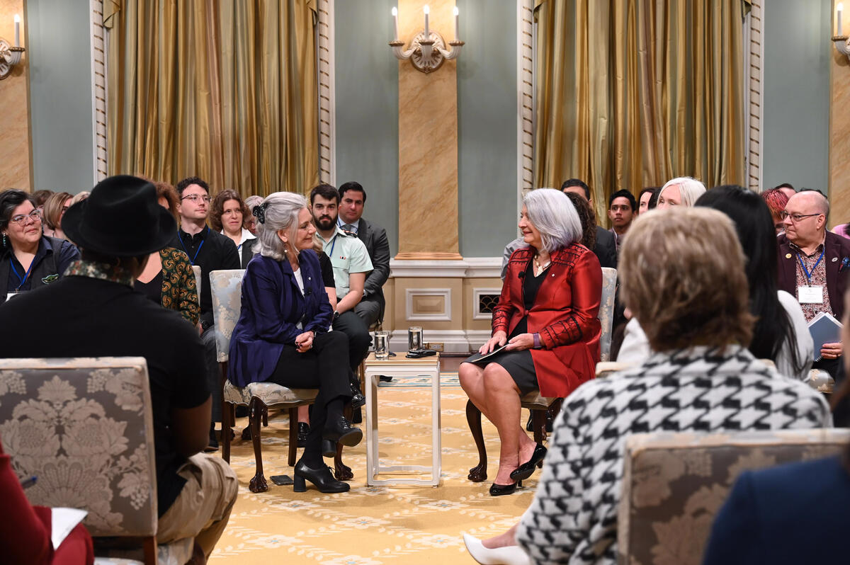 Governor General Mary Simon speaks with Lisa LaFlamme sitting in chairs in the Ballroom